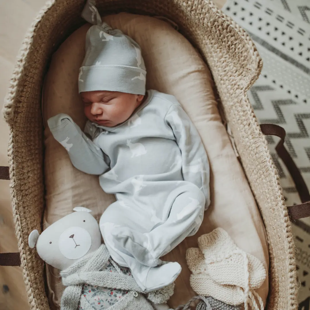 Recien nacido durmiendo placidamente en un cuco o cesta de material natural. Nacimiento
