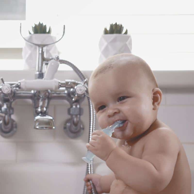 Bebé mordiendo el cepillo de dientes Haakaa. Dolor dentición